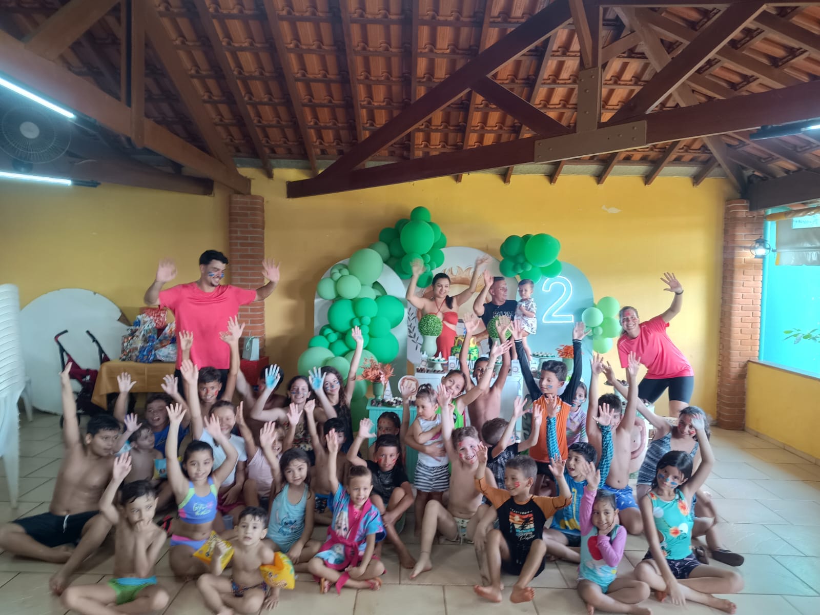 Crianças reunidas em atividade com recreador em ambiente interno