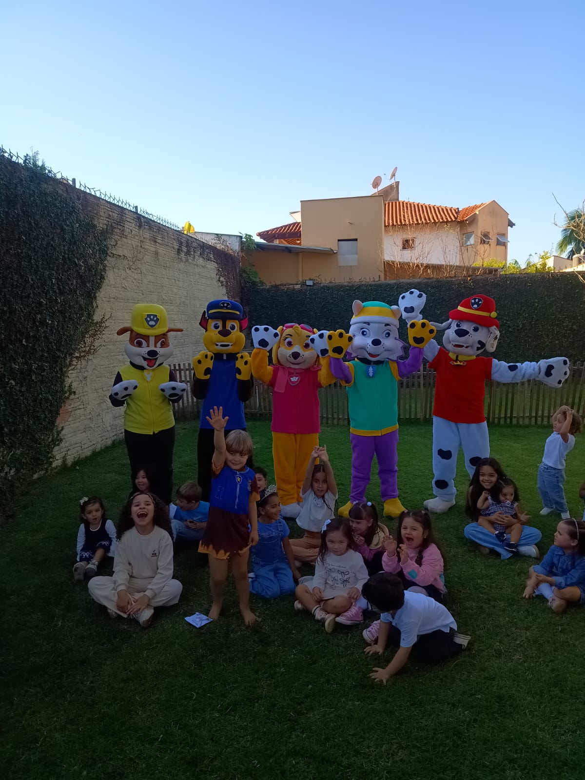 Grupo de crianças com equipe de recreação em área externa de hotel