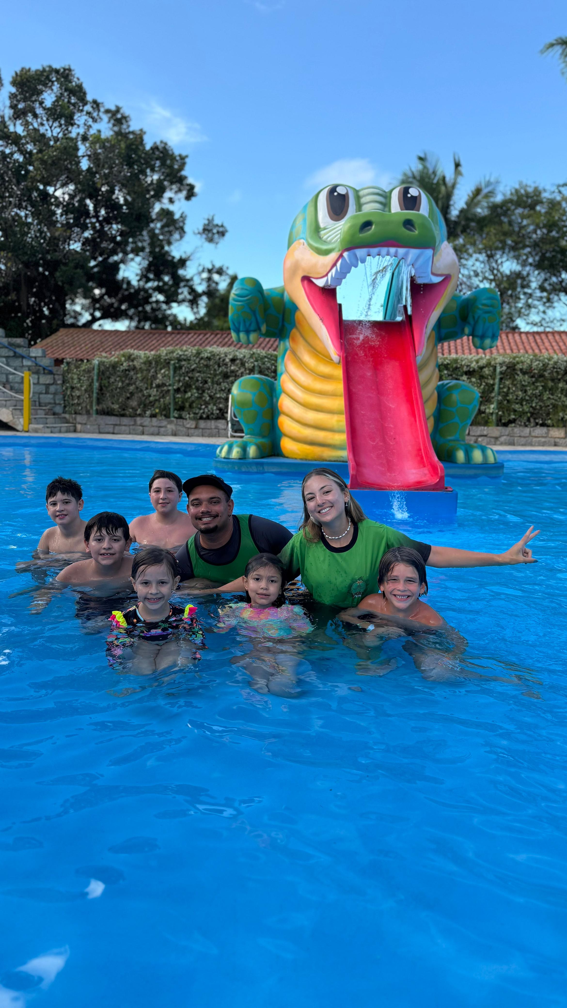 Equipe de recreação e crianças em piscina com brinquedo aquático